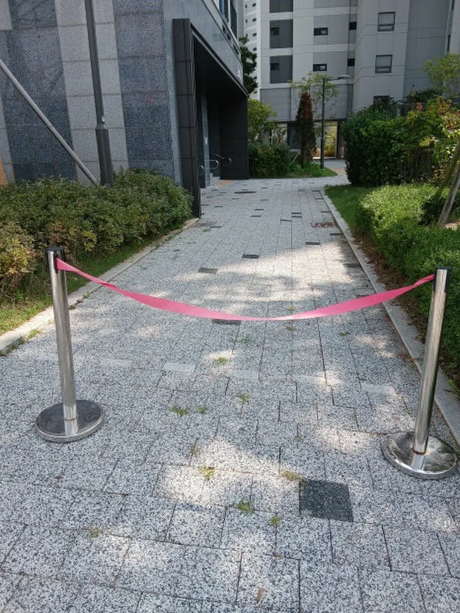 무단주차 방지 시설물 설치 — 보행로 입구를 막은 차단 줄 스탠드